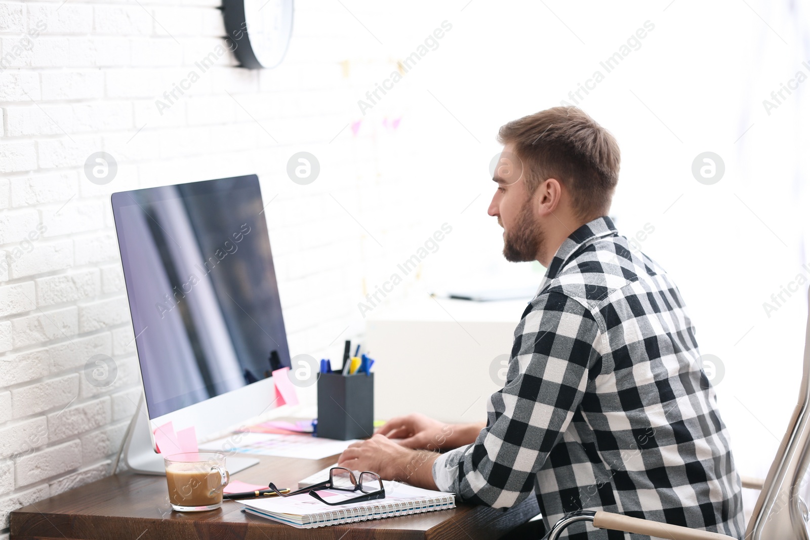 Photo of Male designer working at desk in office