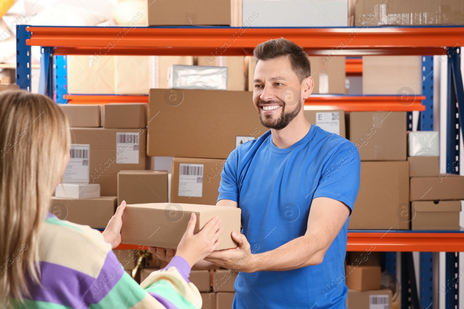 Photo of Worker giving parcel to woman at post office