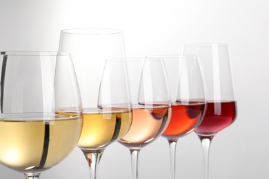 Row of glasses with different wines on white background