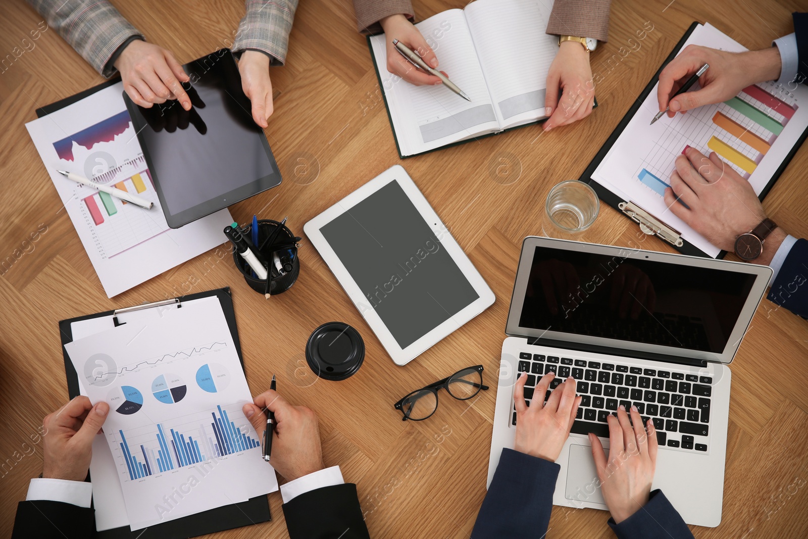 Photo of Businesspeople having meeting at table, top view. Management consulting