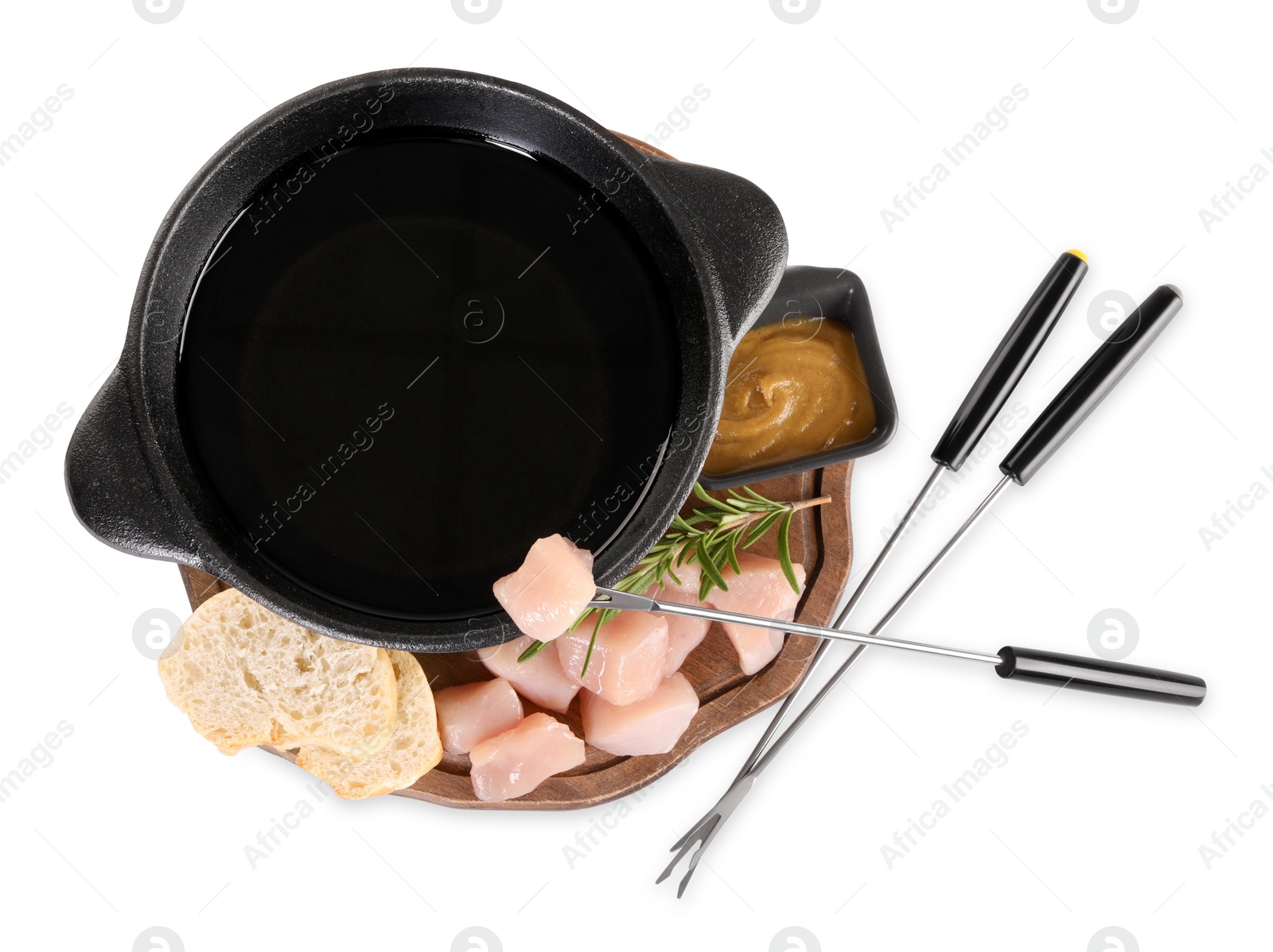 Photo of Fondue pot with oil, forks, raw meat pieces and other products isolated on white, top view