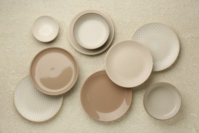 Photo of Beautiful ceramic plates and bowls on beige table, flat lay