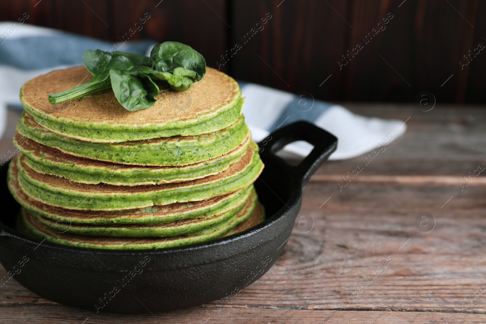 Photo of Tasty spinach pancakes on wooden table, closeup