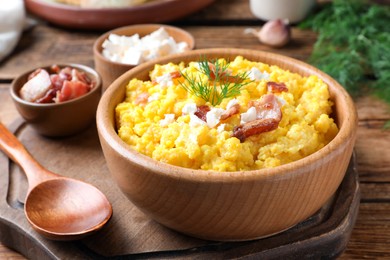 Tasty banosh served with brynza and pork cracklings on wooden table, closeup. Traditional Ukrainian dish