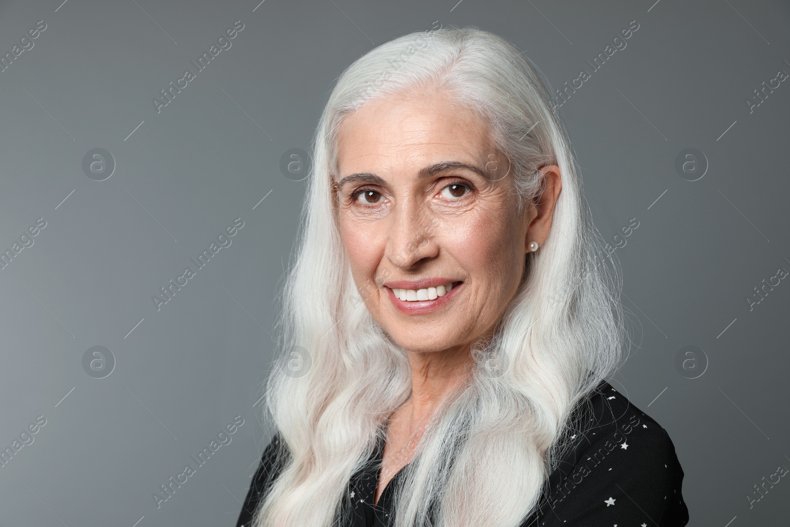 Photo of Portrait of beautiful mature woman on grey background, space for text