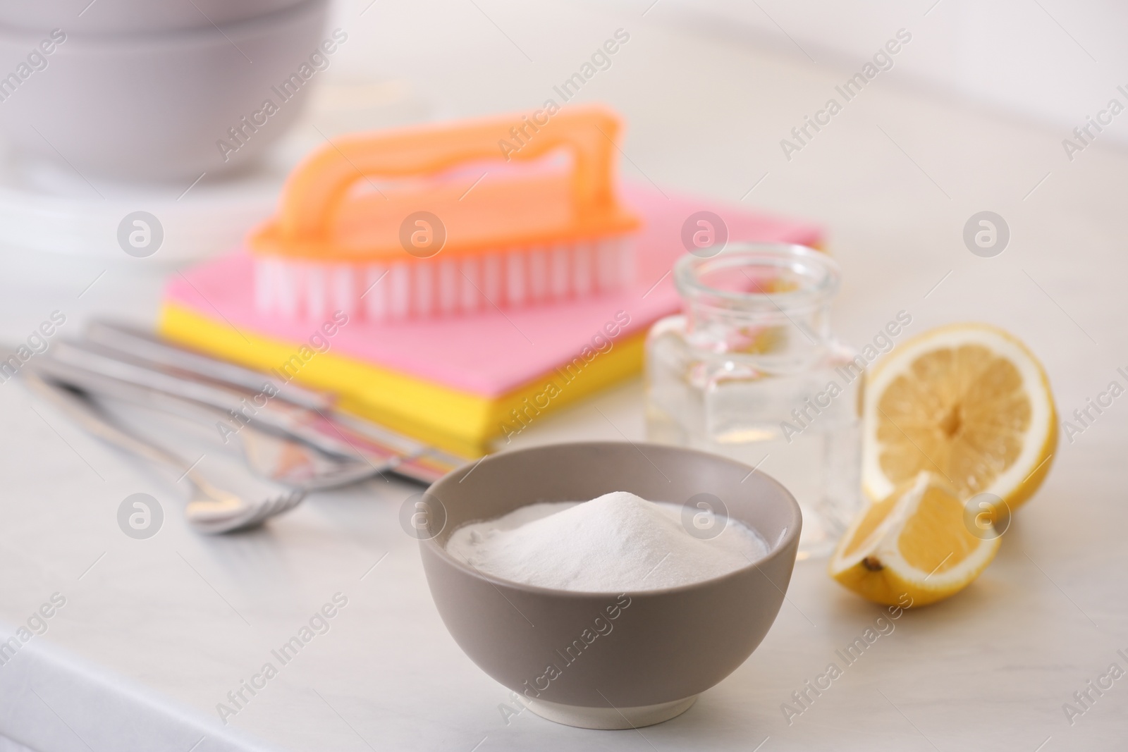 Photo of Baking soda, lemon and vinegar on white table. Eco friendly detergents