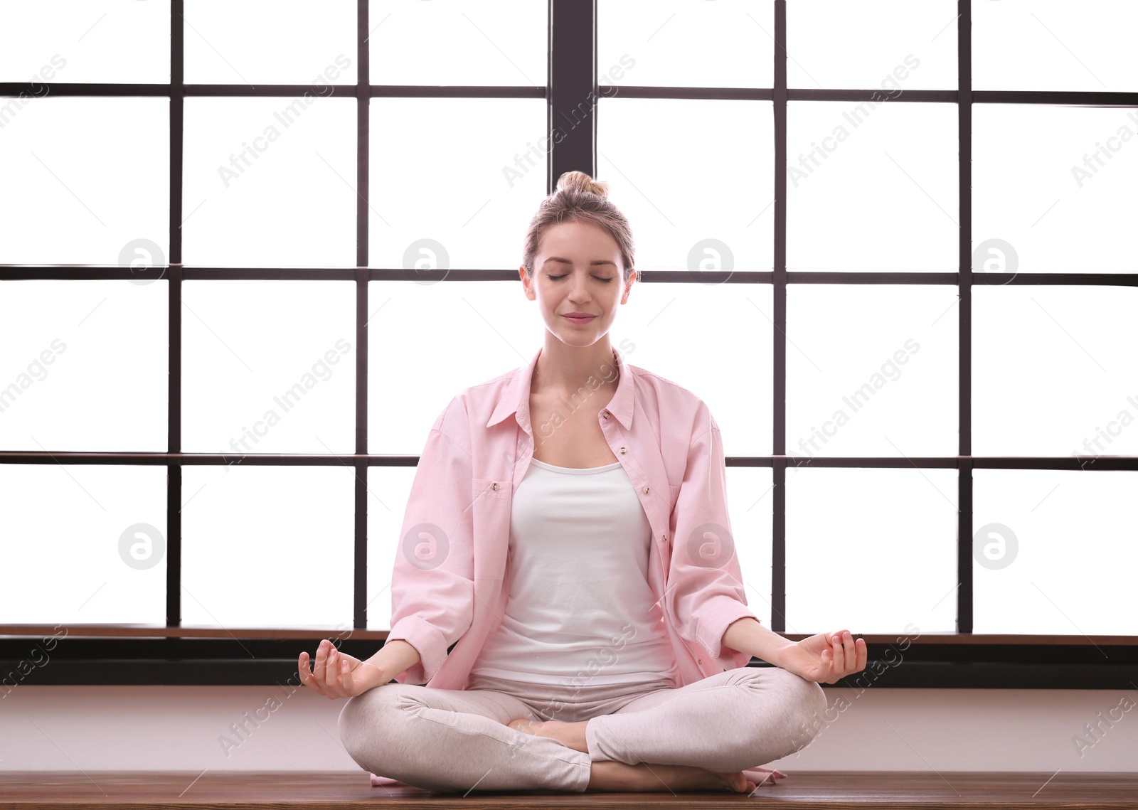 Photo of Young woman meditating at home. Zen concept