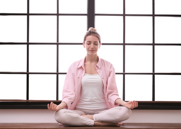 Photo of Young woman meditating at home. Zen concept