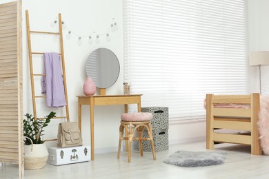 Photo of Stylish teenager's room interior with wooden furniture and mirror