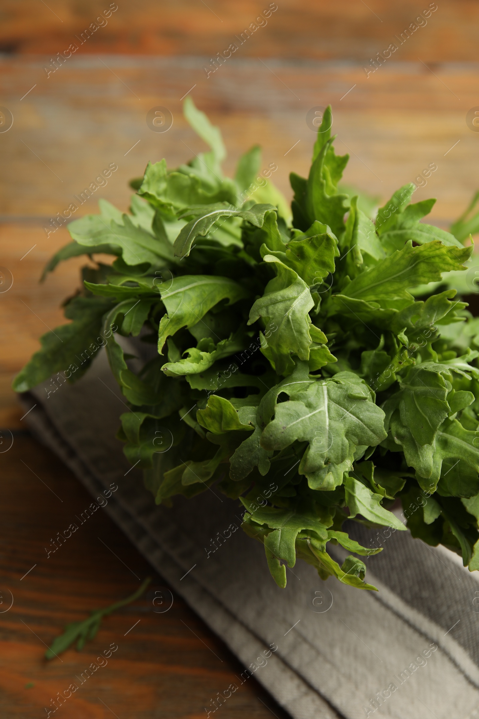 Photo of Fresh arugula on wooden table, closeup view