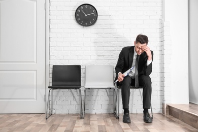 Photo of Young man waiting for job interview, indoors