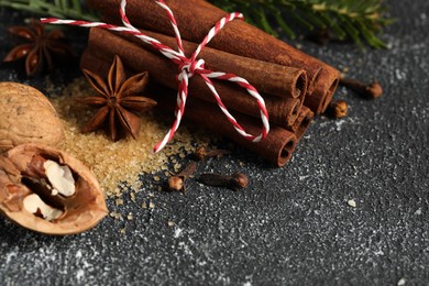 Photo of Different aromatic spices on grey textured table, closeup. Space for text