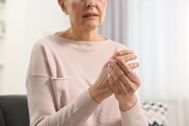 Photo of Arthritis symptoms. Woman suffering from pain in wrist at home, closeup