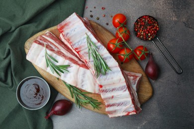 Photo of Flat lay composition with raw pork ribs and sauce on grey table