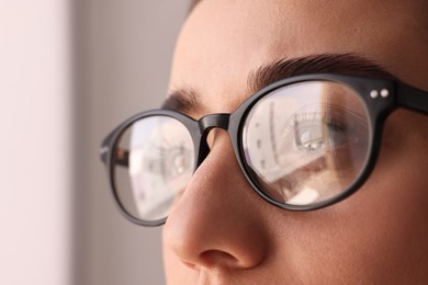 Photo of Woman wearing glasses on blurred background, closeup