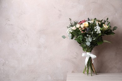 Photo of Beautiful bouquet with roses on white wooden table. Space for text