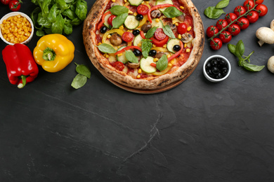 Photo of Flat lay composition with delicious hot vegetable pizza on black table. Space for text
