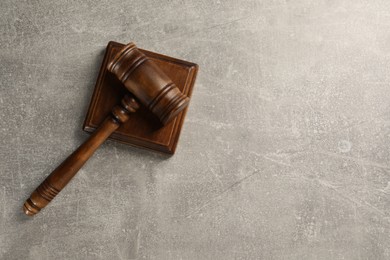 Photo of Wooden gavel on grey textured table, top view. Space for text