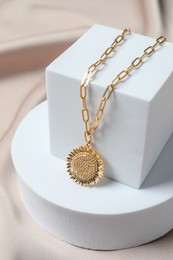 Photo of Stylish presentation of elegant necklace on beige cloth