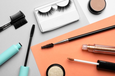 Flat lay composition with false eyelashes and other makeup products on color background