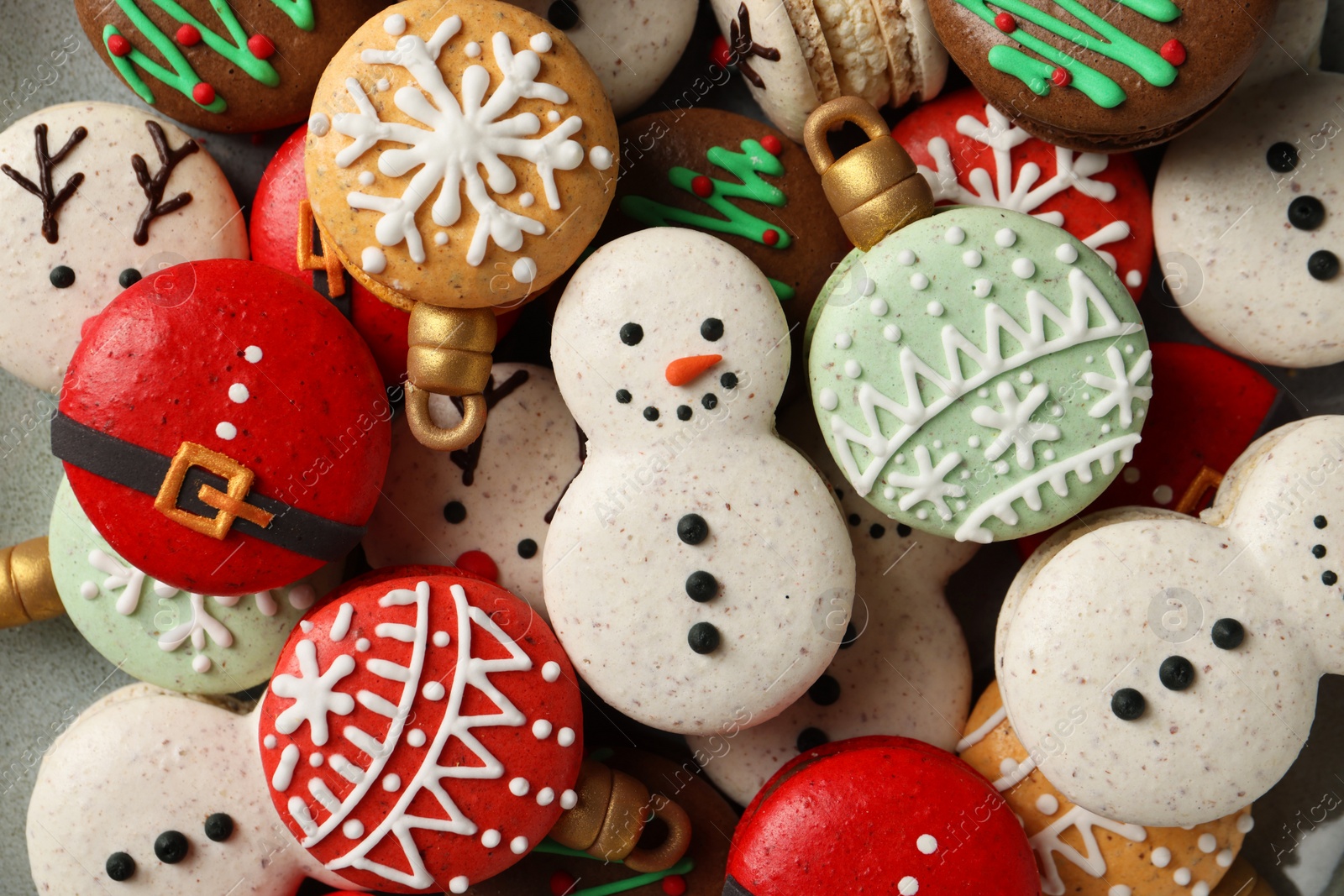 Photo of Beautifully decorated Christmas macarons on plate, top view