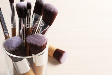 Photo of Set of professional makeup brushes on white background, closeup. Space for text