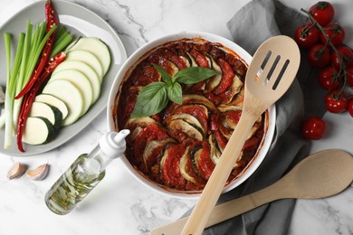 Delicious ratatouille and ingredients on white marble table, flat lay