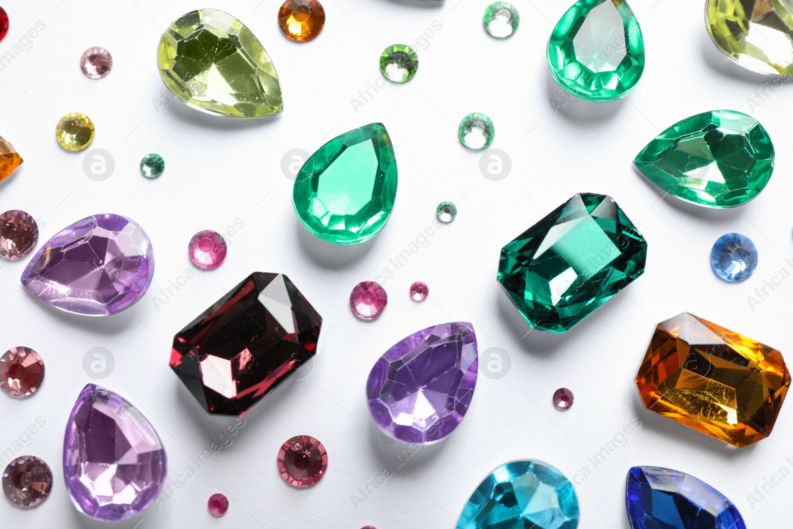 Photo of Different beautiful gemstones on white background, top view