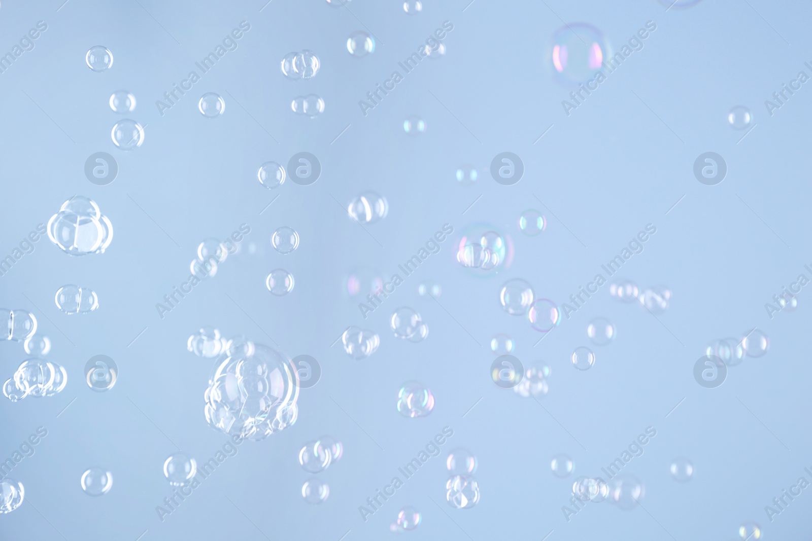 Photo of Beautiful transparent soap bubbles on light grey background