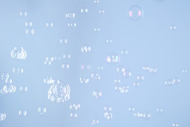 Beautiful transparent soap bubbles on light grey background