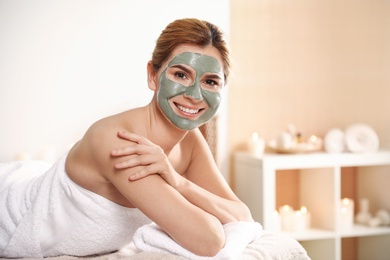 Photo of Beautiful woman with mask on face relaxing in spa salon. Space for text