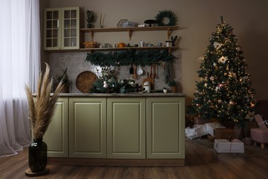 Stylish kitchen with festive decor and Christmas tree. Interior design