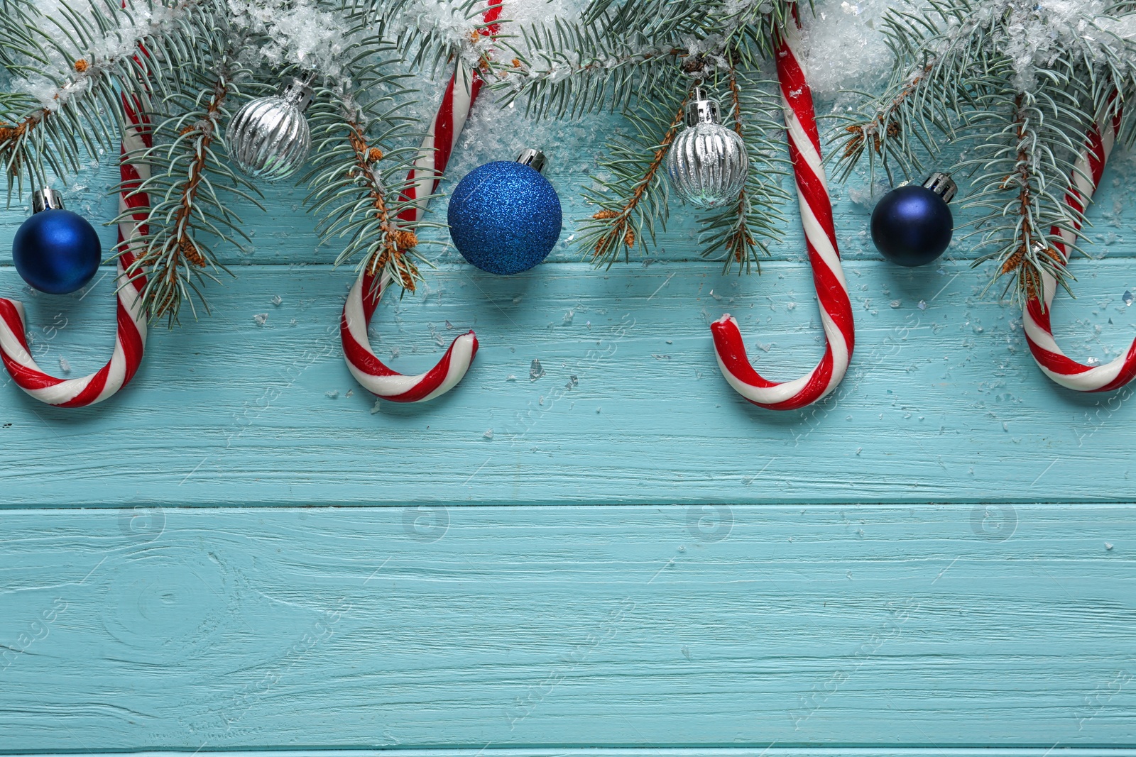 Photo of Candy canes and Christmas decor on blue wooden background, flat lay with space for text