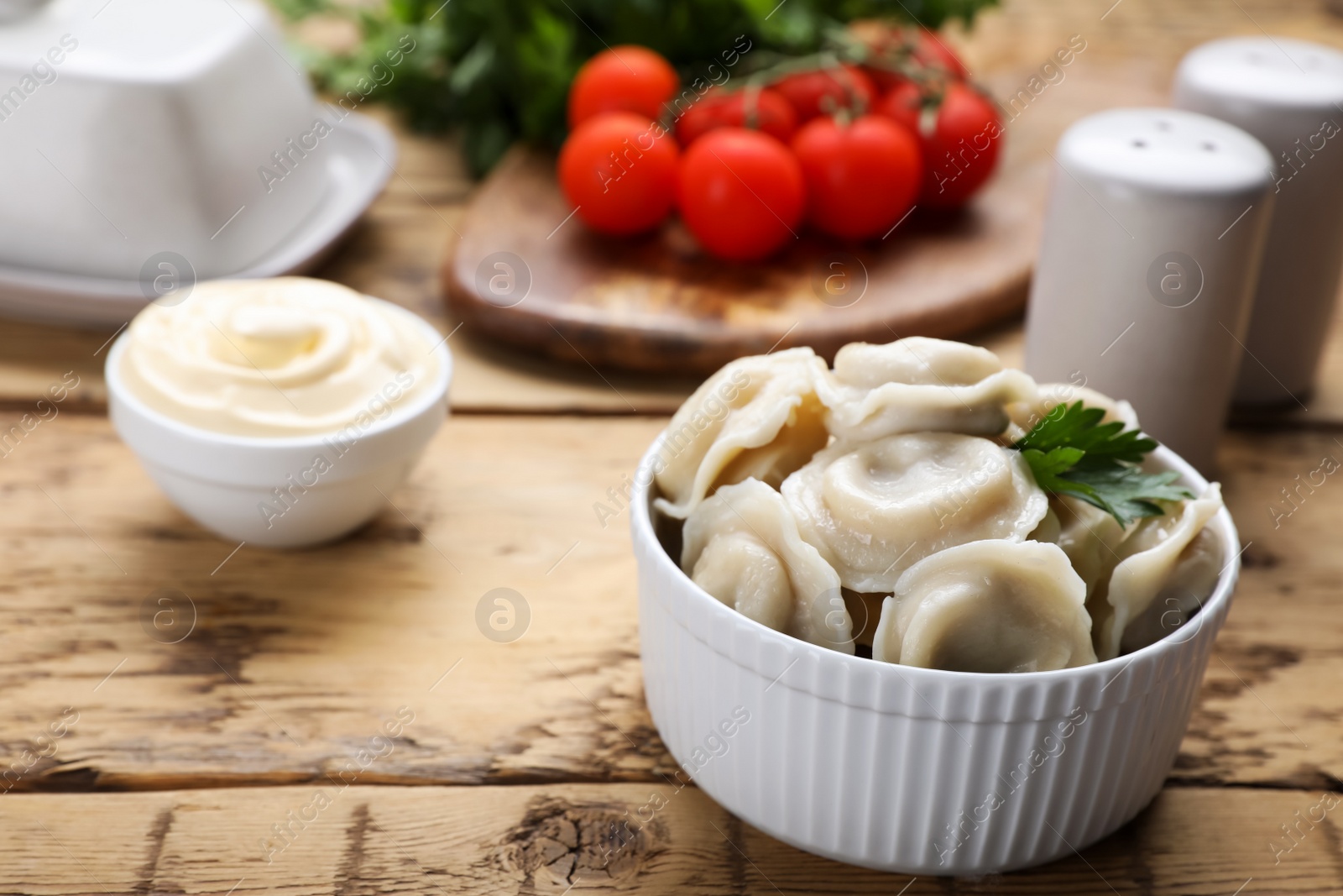 Photo of Tasty dumplings in bowl on wooden table