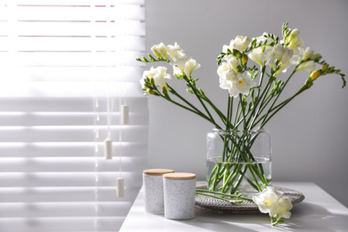 Photo of Beautiful spring freesia flowers on table in room