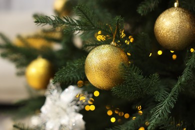 Photo of Christmas balls hanging on fir tree, closeup