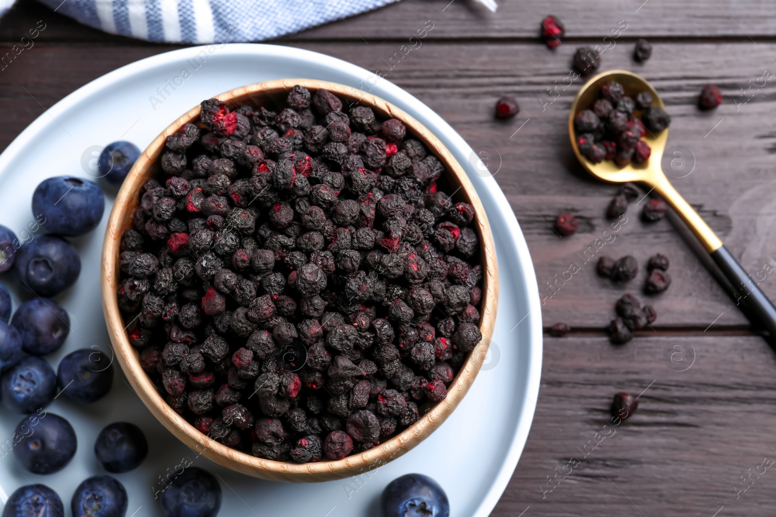 Photo of Freeze dried and fresh blueberries on wooden table, flat lay