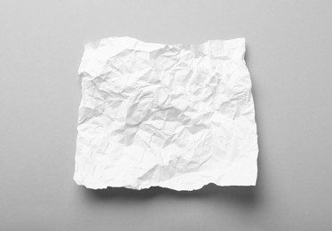 Photo of Sheet of white crumpled paper on grey background, top view