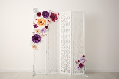 Photo of Ornate white folding screen with floral decor indoors. Beautiful photo zone