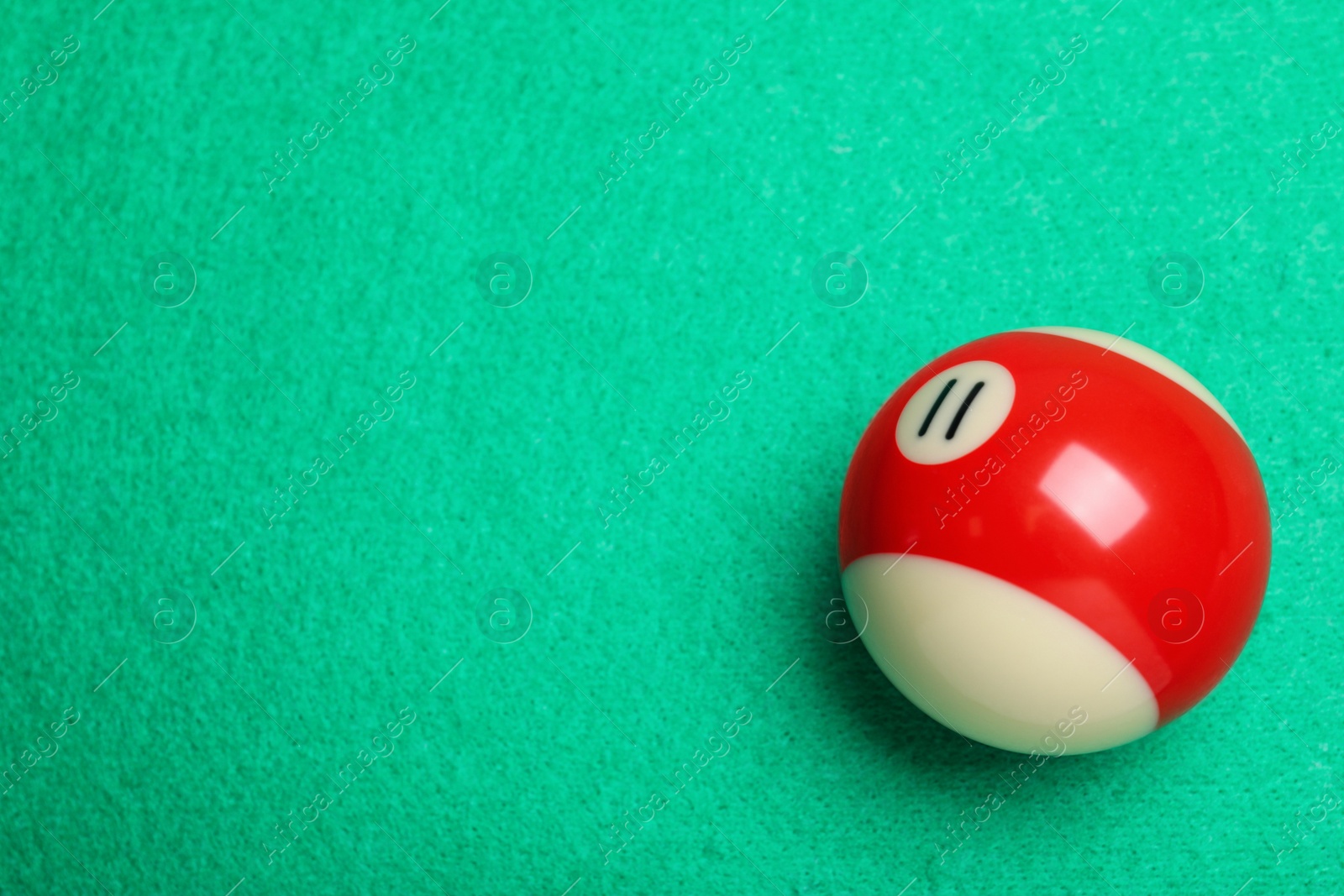 Photo of Billiard ball with number 11 on green table, top view. Space for text