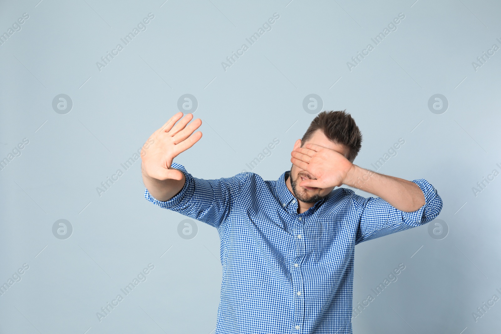 Photo of Handsome man being blinded on grey background