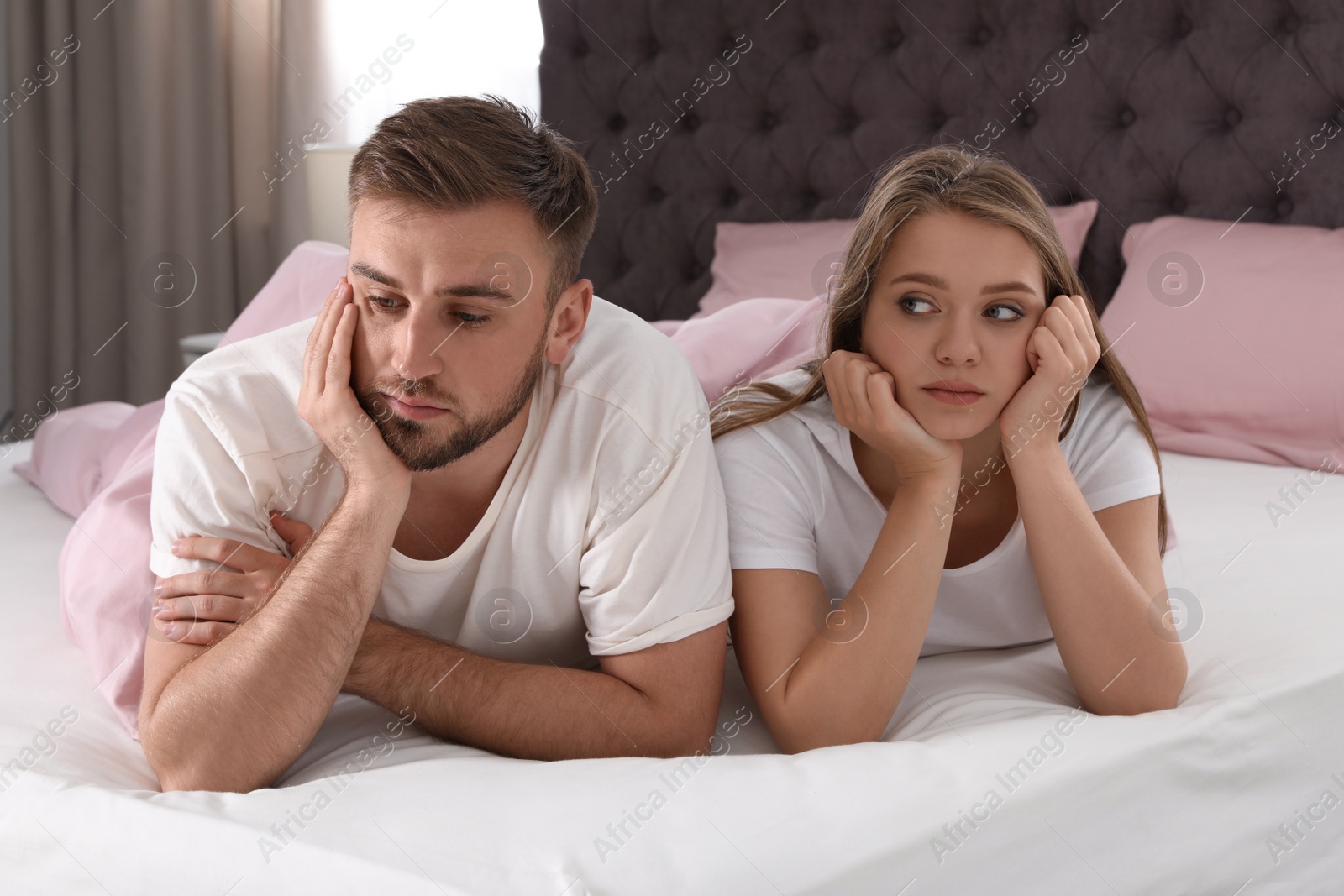 Photo of Young couple with relationship problems in bed at home