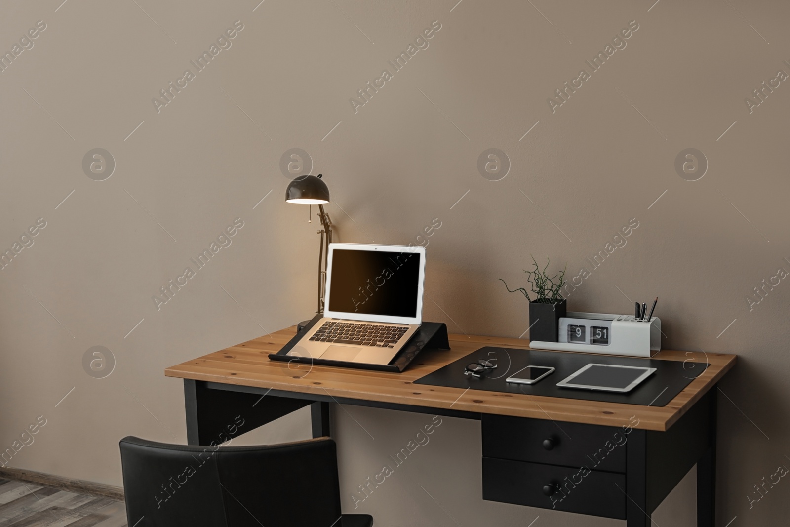 Photo of Modern workplace interior with laptop and devices on table. Space for text