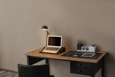 Modern workplace interior with laptop and devices on table. Space for text