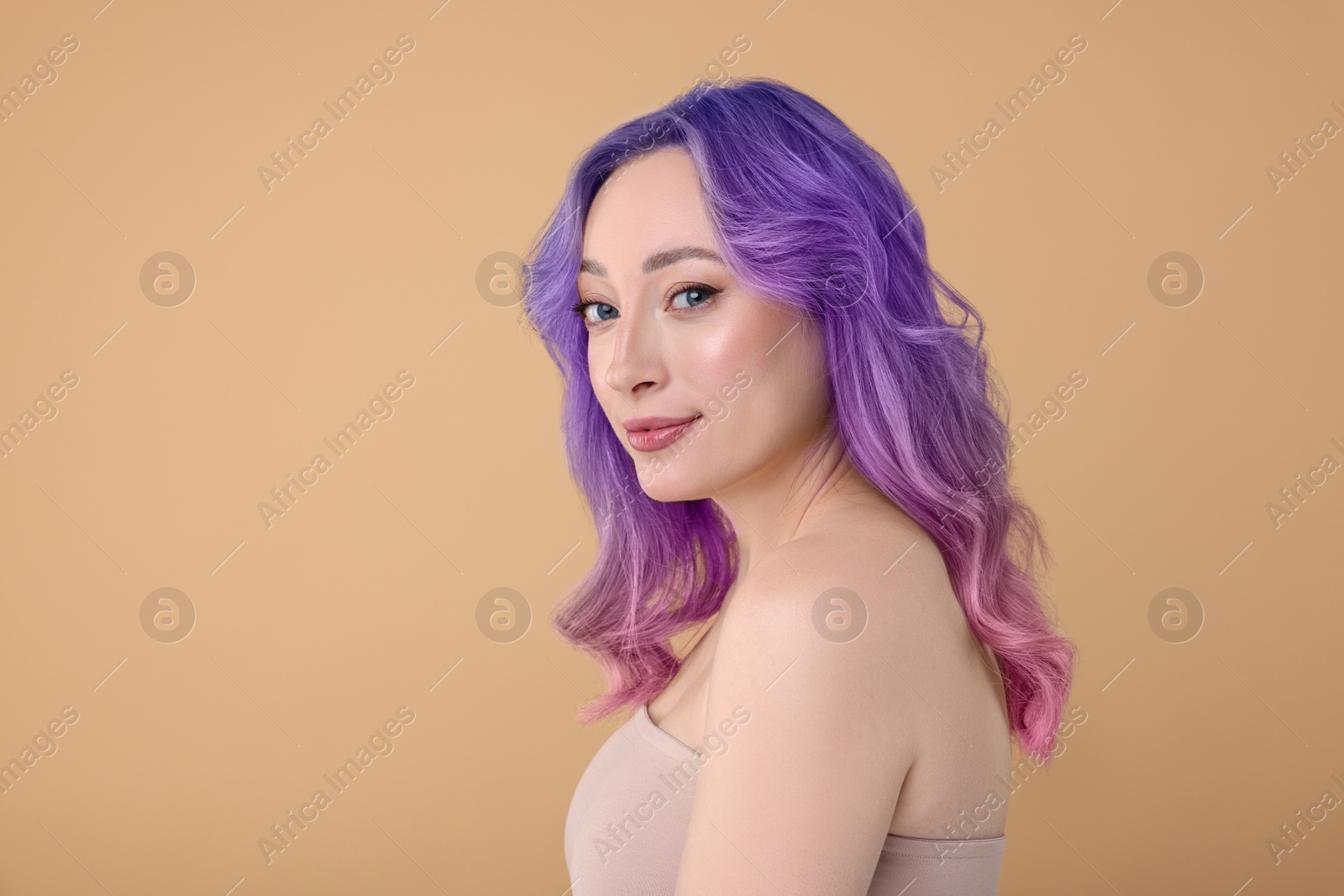 Image of Trendy hairstyle. Young woman with colorful dyed hair on dark beige background. Space for text