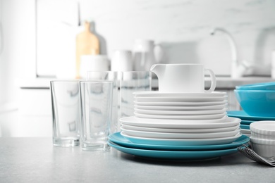 Photo of Set of clean dishes on table in kitchen