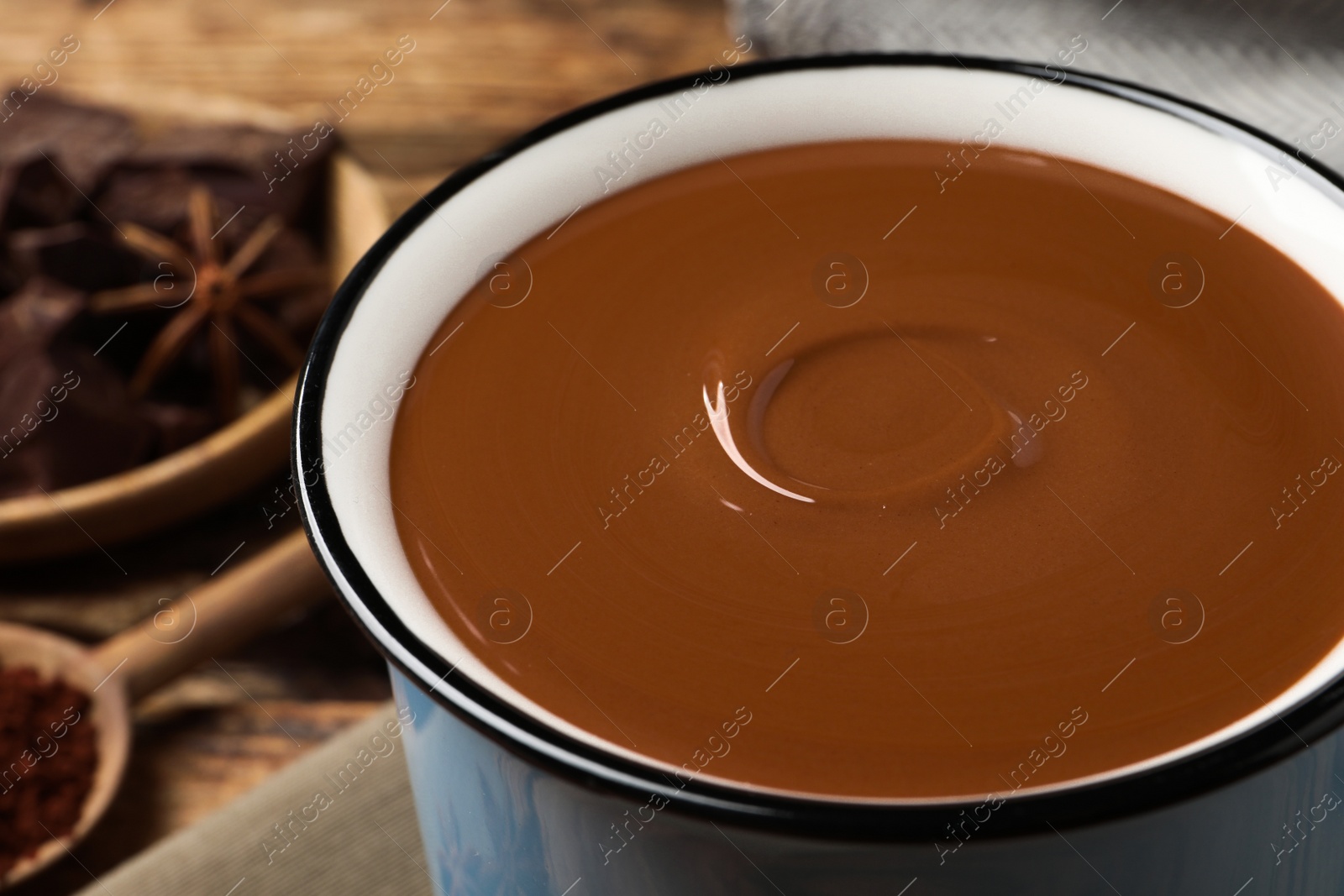 Photo of Yummy hot chocolate in light blue mug, closeup