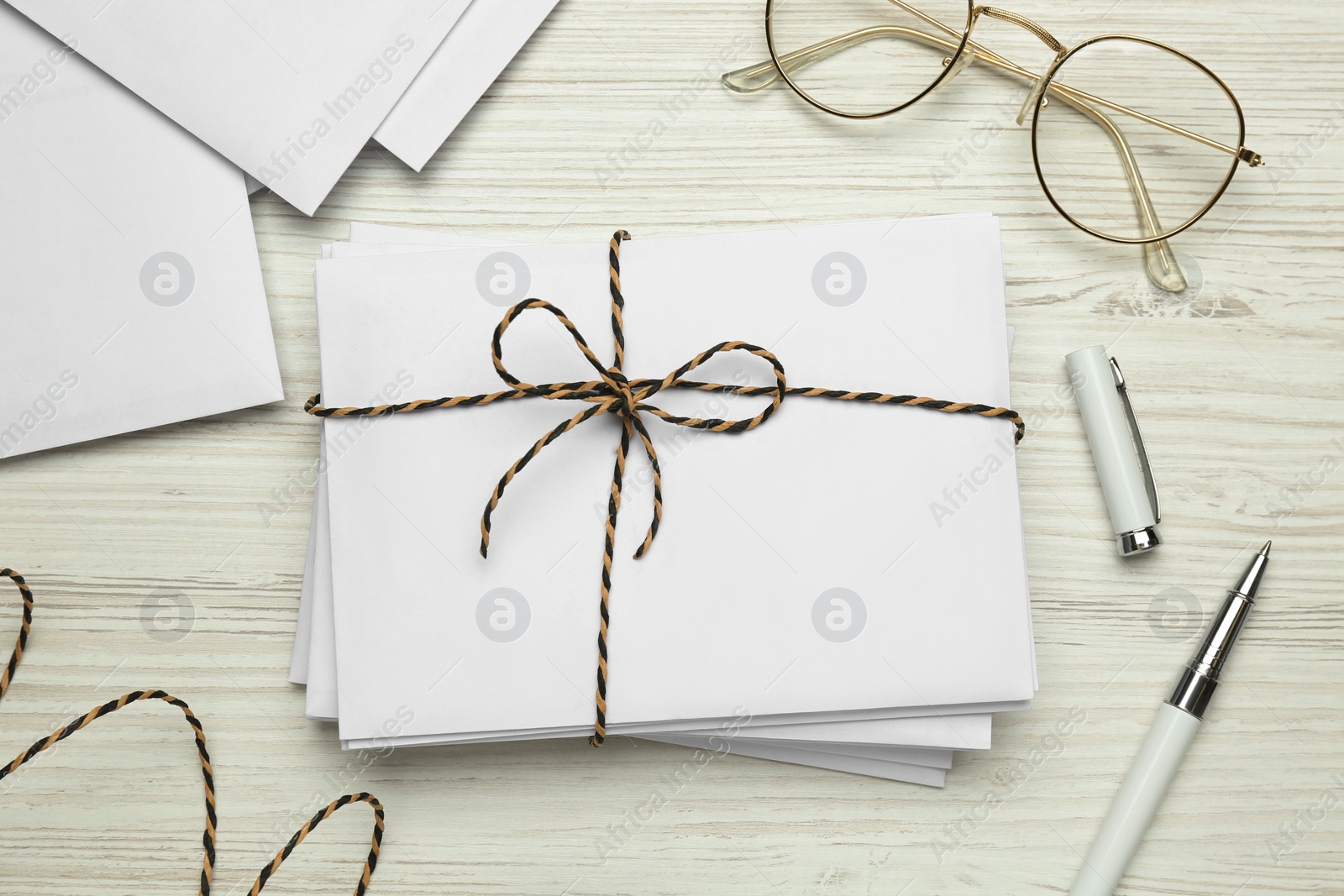 Photo of Letters, pen and glasses on white wooden table, flat lay