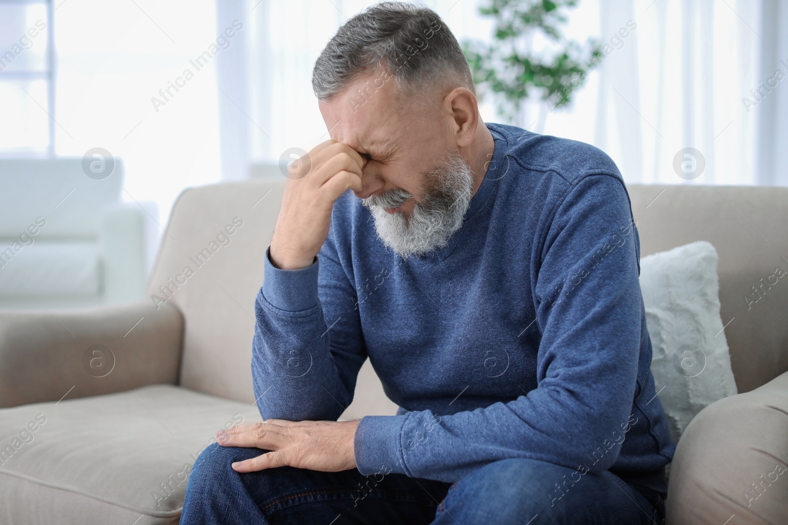 Photo of Mature man suffering from headache at home