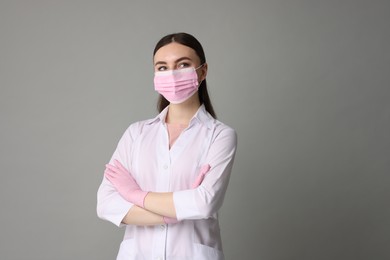Cosmetologist in medical uniform on grey background